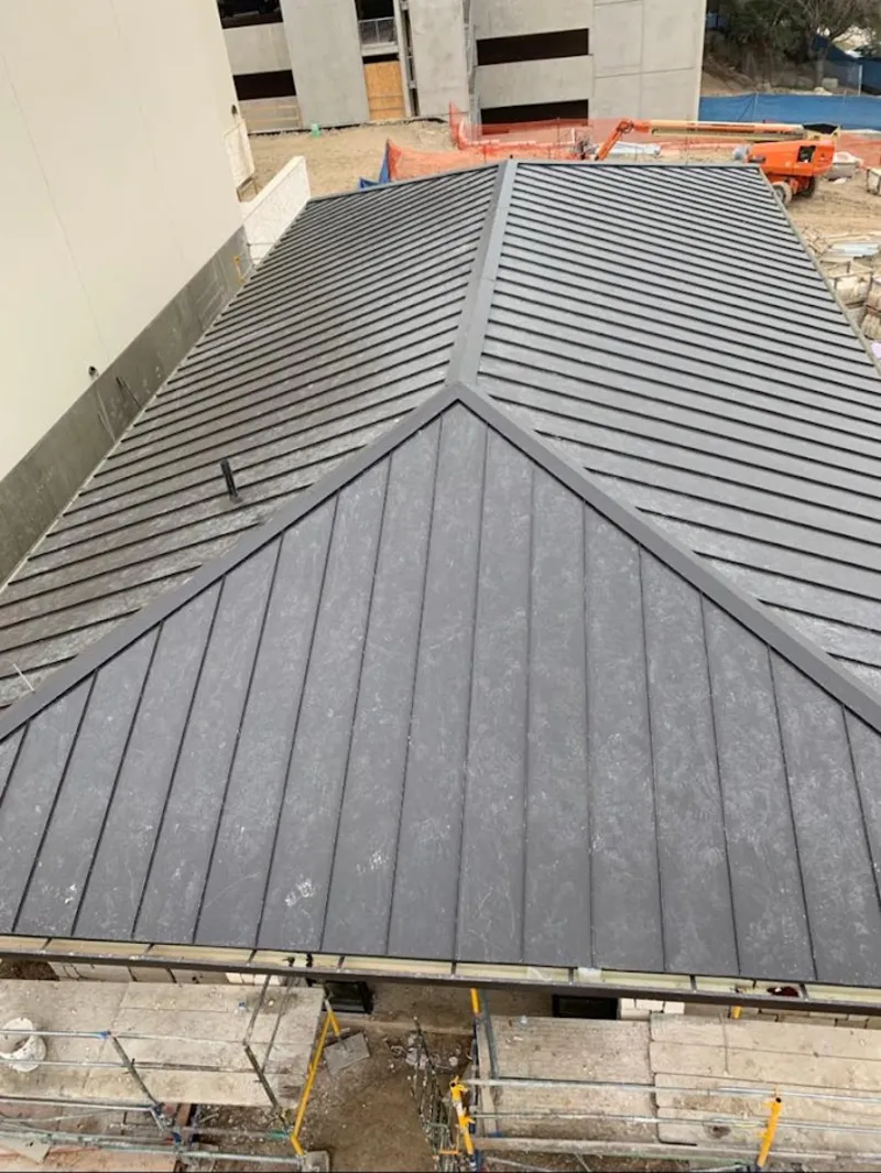 Commercial metal roof construction with crane equipment in Concord